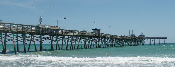 A wooden fishing pier stretching into the ocean on the Crystal Coast, North Carolina